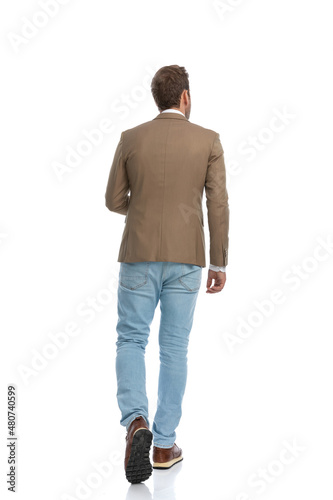 businessman wearing a brown suit and walking away