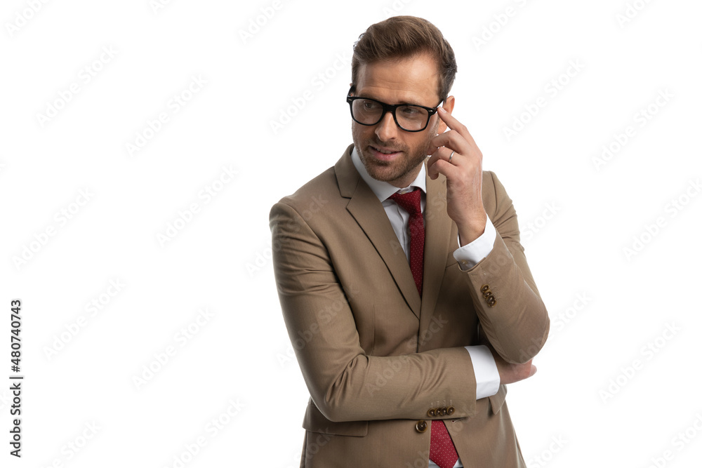 sexy fashion model looking away, arranging his glasses sexy fashion model looking away, arranging his glasses
