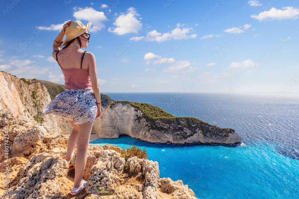 Woman tourist in Zakynthos, Greece admiring the Navagio beach Woman tourist in Zakynthos, Greece admiring the Navagio beach