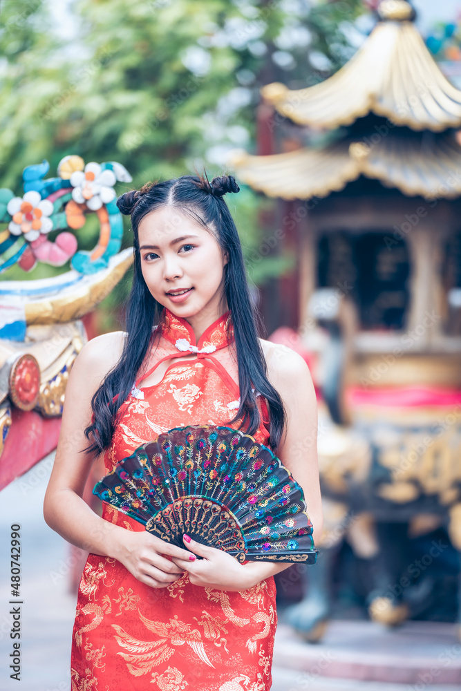 Portrait of Asian beautiful woman wearing red traditional Chinese, Asian woman holding Chinese fan for Chinese new year theme. Chinese new year concept, Vintage Tone.