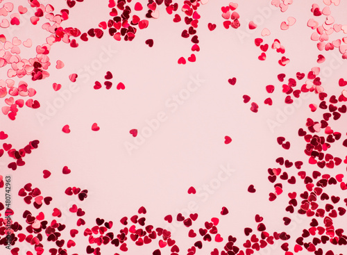 Fototapeta Naklejka Na Ścianę i Meble -  Frame of small red hearts on a pink background. Valentine's Day. Layout design for text. Copy space.