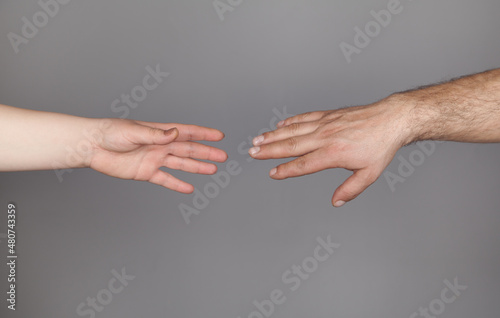 Hands of man and woman holding together  Gray background.