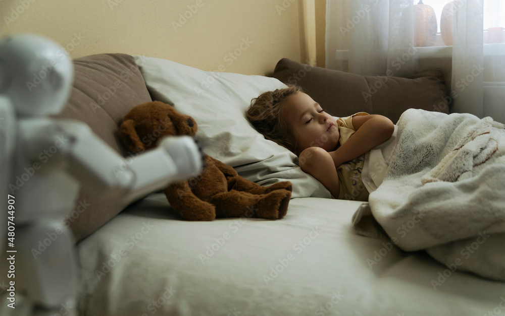 Portrait of cute little girl sleeping in bed with toy bear and toy robot in the foreground Portrait of cute little girl sleeping in bed with toy bear and toy robot in the foreground