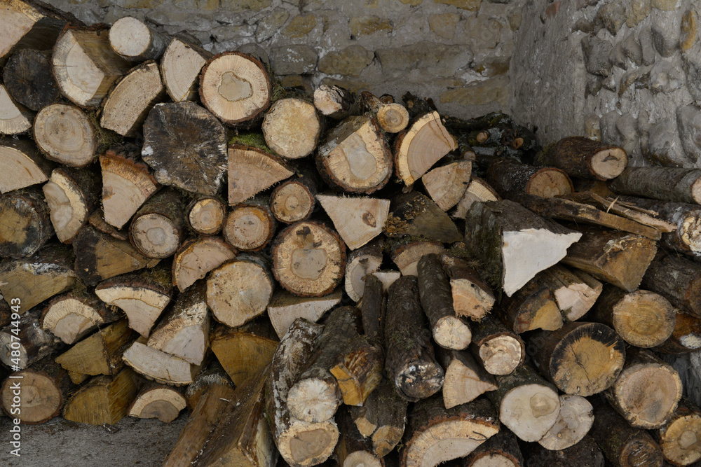Pile de bois de chauffage coupé rangé dans un abri en pierres Pile de bois de chauffage coupé rangé dans un abri en pierres