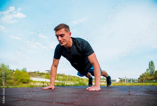 Fit man doing clapping push-ups during training exercise workout
