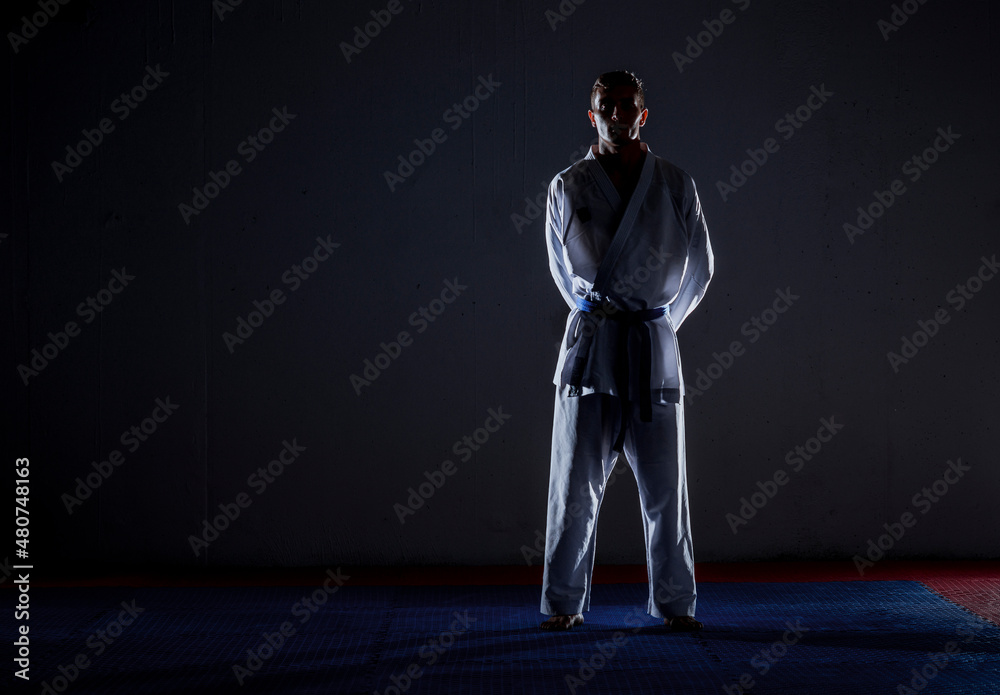 Obraz premium The karate guy in white kimono and black belt training karate