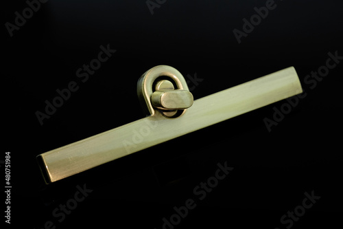 Decorative twist lock of bronze color on a black background. Bag lock. Accessories for sewing bags. Decorative decorations for accessories. photo