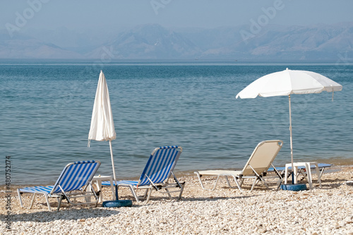 Fototapeta Naklejka Na Ścianę i Meble -  Deck chairs and beach umbrellas on the beach in Corfu, Greece