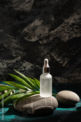 Layout for your cosmetics or product with natural stones background made of environmentally friendly materials. The concept of an ecological lifestyle, a layout for the sale of serum, vertical photo.