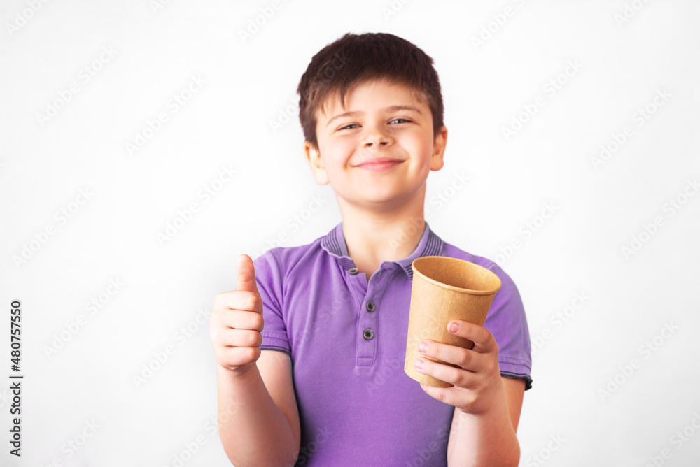 smiling boy holds a plastic and a paper drinking cup in the hands. Promotion of non-use of plastic. Zero waste concept smiling boy holds a plastic and a paper drinking cup in the hands. Promotion of non-use of plastic. Zero waste concept