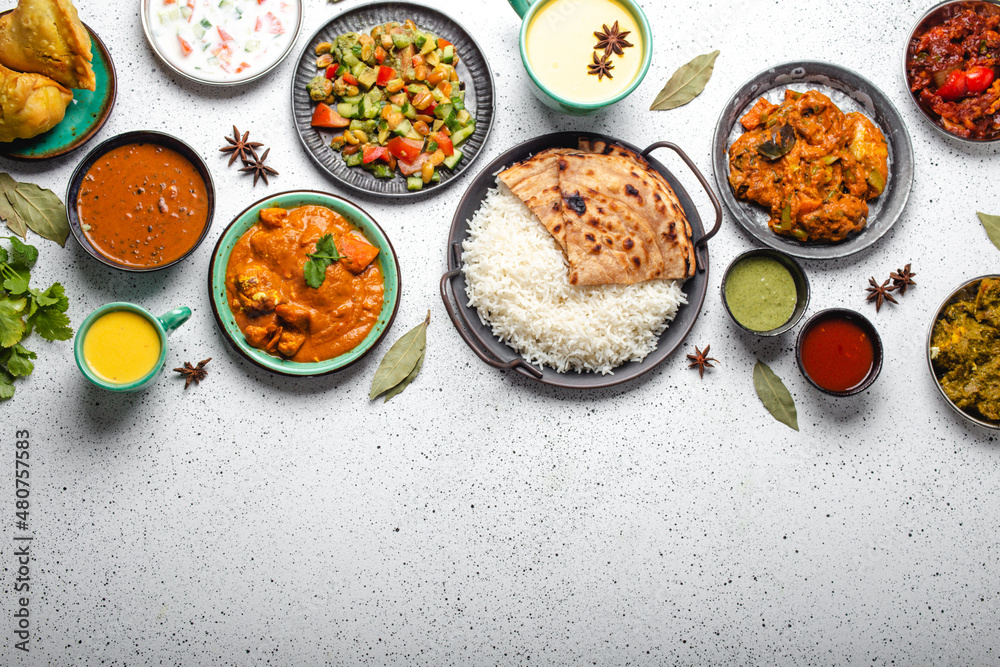Obraz na plátně Indian ethnic food buffet on white concrete table top view: curry, samosa, rice