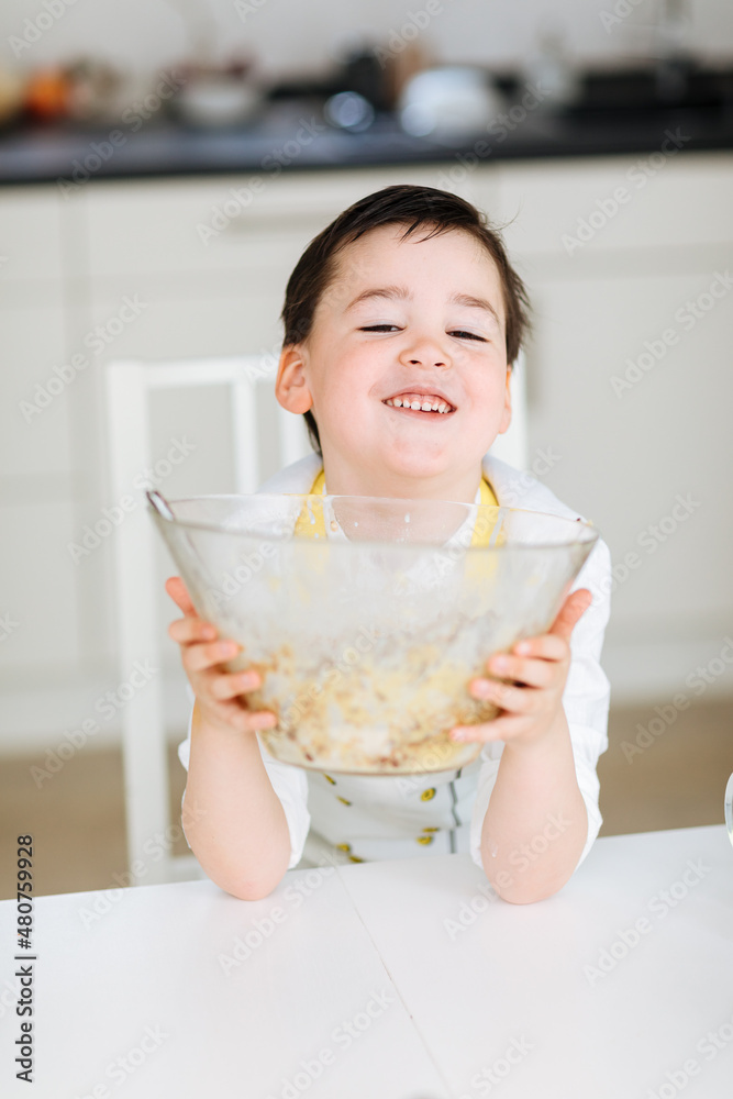 Little boy makes muffins. Child bakes cakes. Baking during the pandemic. Cupcakes made by children. cooking school, cooking lessons Little boy makes muffins. Child bakes cakes. Baking during the pandemic. Cupcakes made by children. cooking school, cooking lessons