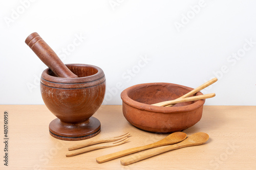 Set of various traditional kitchen utensils, made of wood and a clay bowl