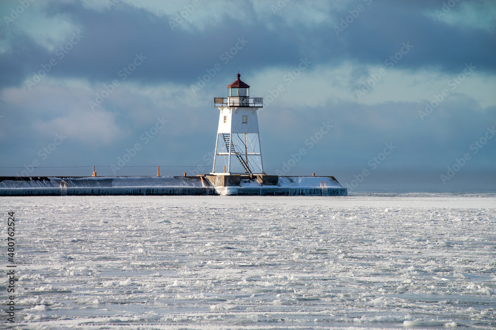 lighthouse in the harbor. Frozen icy lake