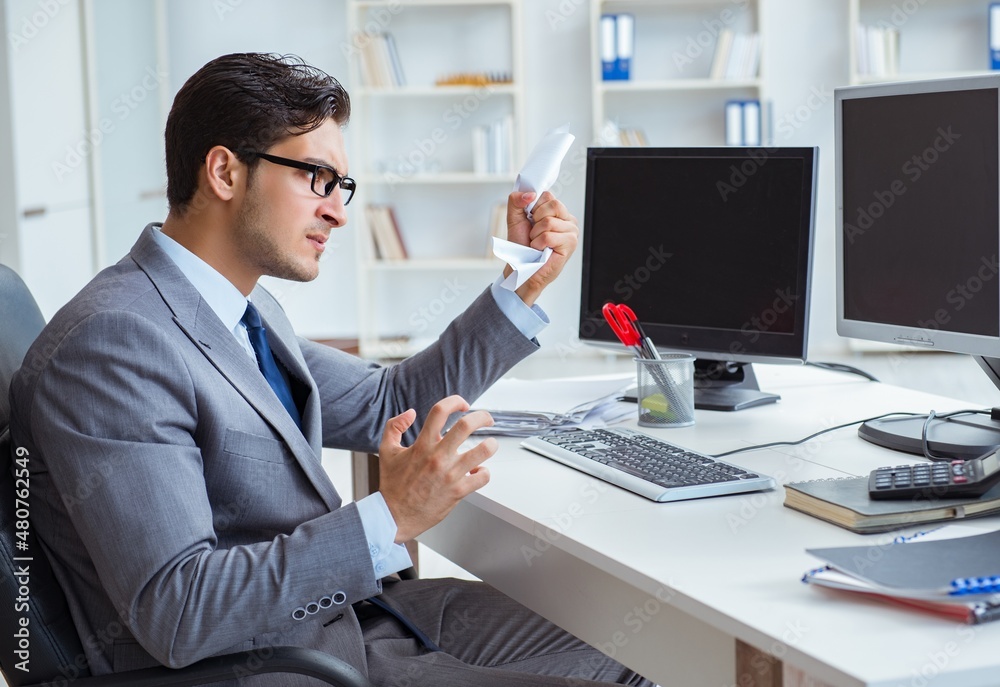 Businessman sitting in front of many screens