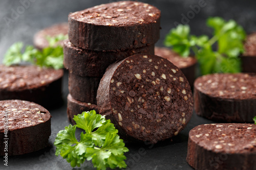 Raw Black Pudding with parsley on rustic stone board