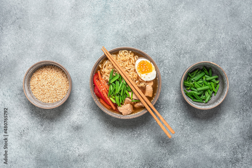 Japanese food. Ramen noodle soup with chicken, vegetables and eggs. Gray concrete rustic background. Top view Japanese food. Ramen noodle soup with chicken, vegetables and eggs. Gray concrete rustic background. Top view