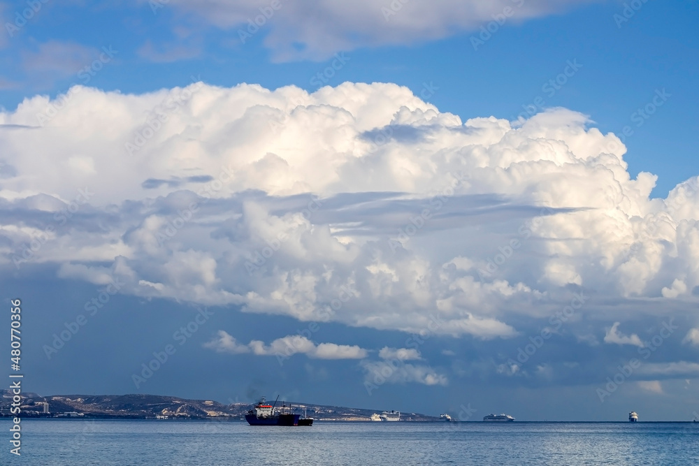 Cloudy winter sky above the mountains and the sea with ships