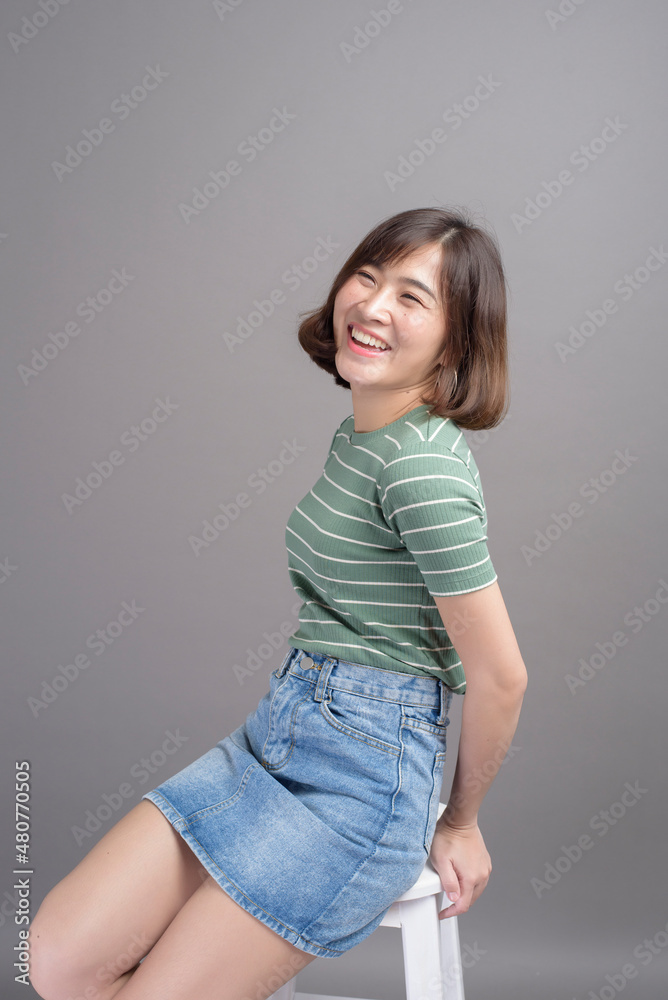 Portrait of young beautiful asian woman over studio background.