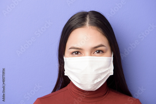 portrait of A young woman is wearing face mask on purple background