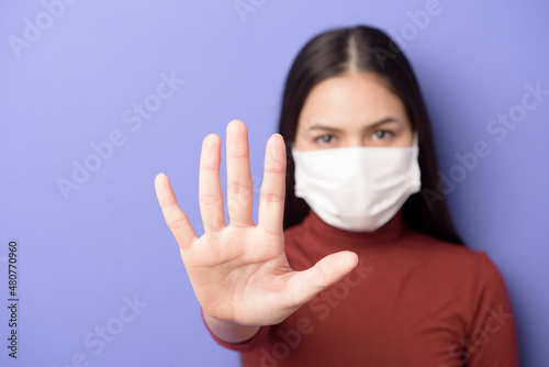 portrait of A young woman is wearing face mask on purple background