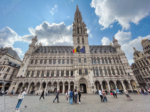 Gothic town hall building in Brussels, capital of Brussels and Europe, at the Grand Place with tourists and blue sky with white clouds photo