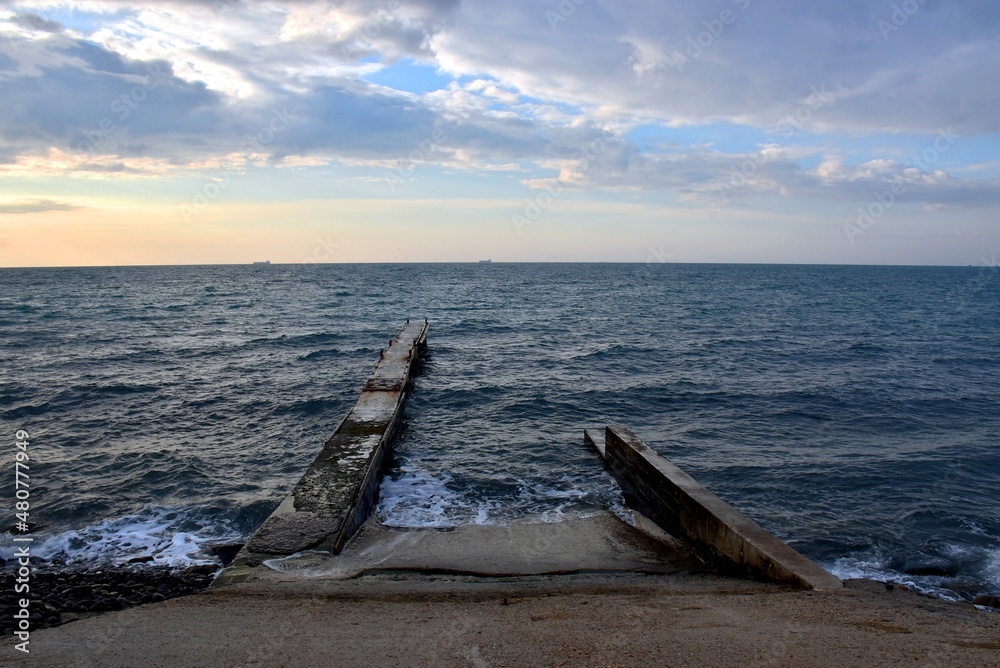 Sea pier on the background of the winter cold sea Sea pier on the background of the winter cold sea