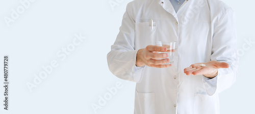 Healthcare, medical: Close up doctor giving capsule and glass of water isolated over grey color background