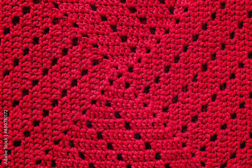 Knitted red texture. Crocheted granny square.