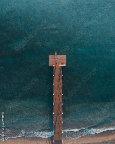 Aerial drone top down photo of pier and blue sea 