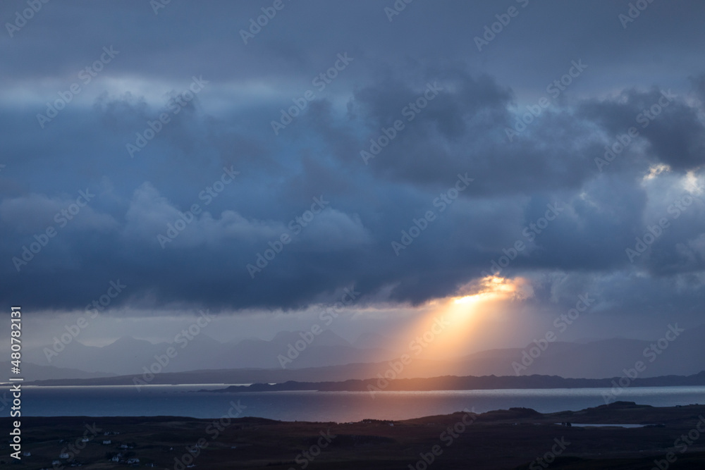 Rays of light at sunrise with cloudy and rainy weather. Scotland, UK.