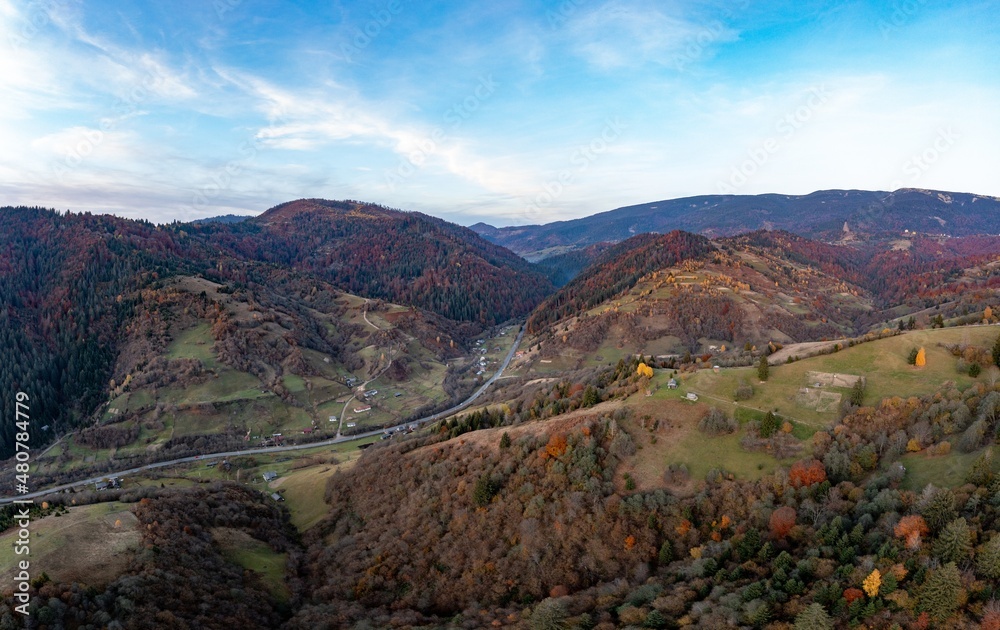 Ground road in high mountains with green forest at sunrise