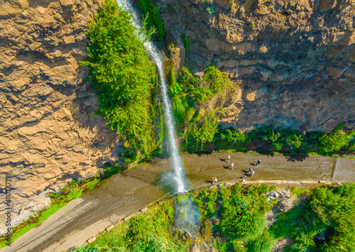 Fototapeta Naklejka Na Ścianę i Meble -  Aerial drone view of Angels waterfall (Cascata dos Anjos) in Madeira island. The waterfall cascades over the rockface onto the regional roadway, and spills into the sea below