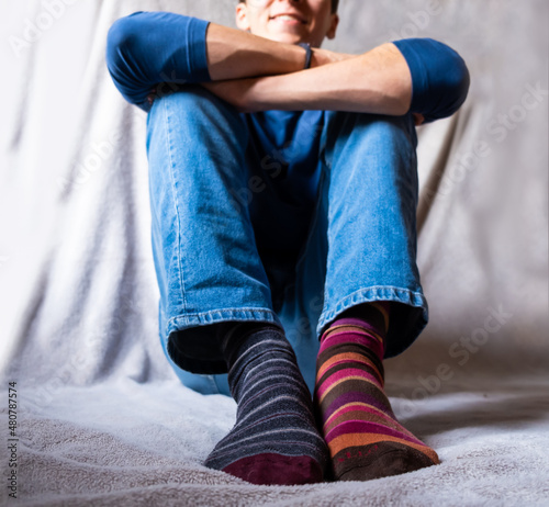 Teenager boy wearing brightly mismatched differend striped socks photo