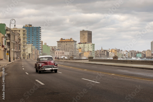 Fototapeta Naklejka Na Ścianę i Meble -  Old car on Malecon street of Havana with storm clouds in background. Cuba