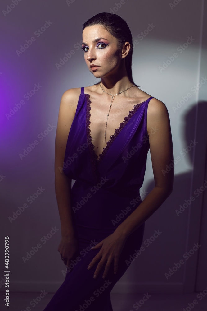 portrait of a brunette woman in a purple dress on white background in the studio portrait of a brunette woman in a purple dress on white background in the studio