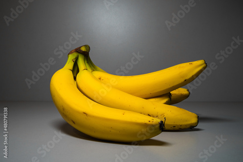 Bunch of yellow bananas on a gray background close-up