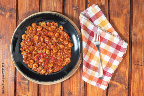 Shrimps with tomato red sauce on wooden table. Top view. photo