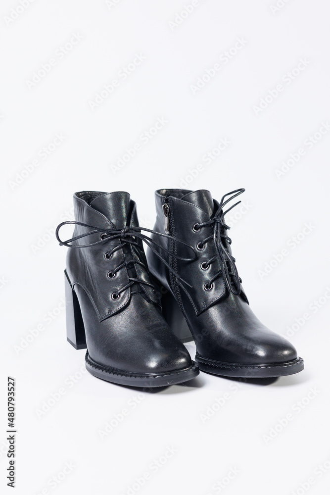 Women's boots with black genuine leather on heels isolated on a white background. photo from the side, diagonally and foreshortened from behind. Women's shoe collection 2022