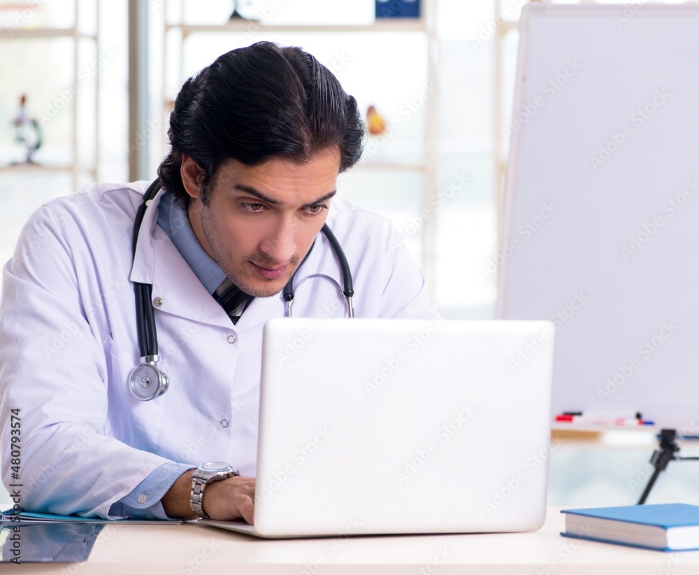 The young handsome doctor in front of whiteboard The young handsome doctor in front of whiteboard