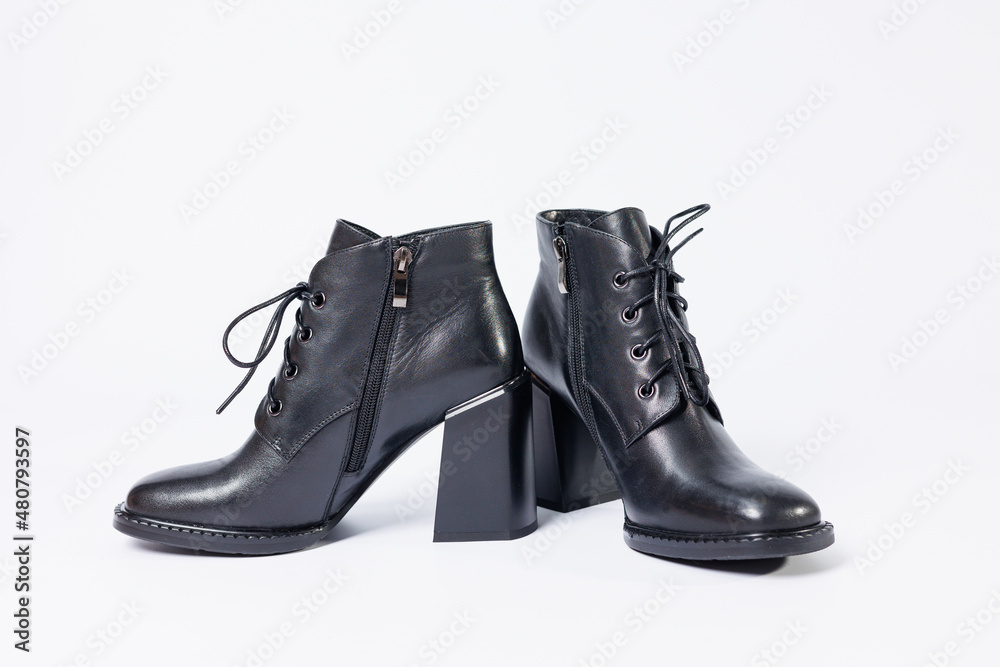 Women's boots with black genuine leather on heels isolated on a white background. photo from the side, diagonally and foreshortened from behind. Women's shoe collection 2022 Women's boots with black genuine leather on heels isolated on a white background. photo from the side, diagonally and foreshortened from behind. Women's shoe collection 2022