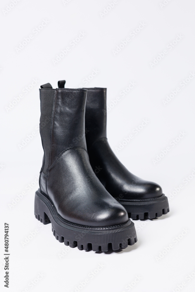 Women's shoes on a white background. Close-up of women's black leather chelsea boots on a white background. Shoes for the city. Fashion, design and footwear concept. Women's shoes on a white background. Close-up of women's black leather chelsea boots on a white background. Shoes for the city. Fashion, design and footwear concept.