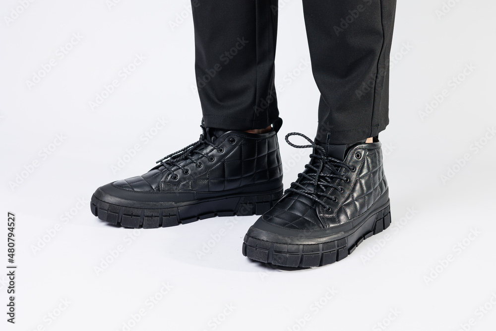 Men's black boots made of genuine leather, men's footwear on a white background. Winter men's shoes 2022