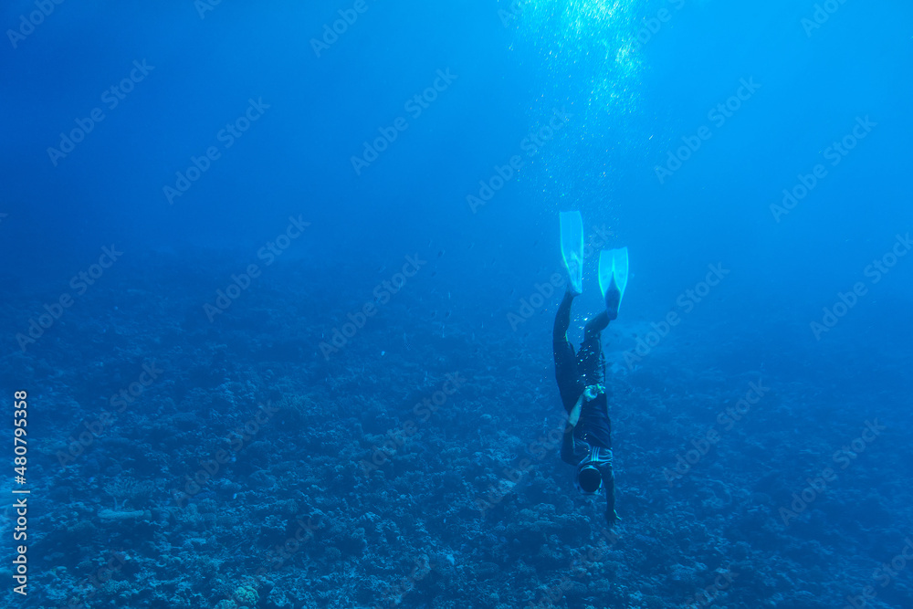 A brave diver dives with a mask under the water