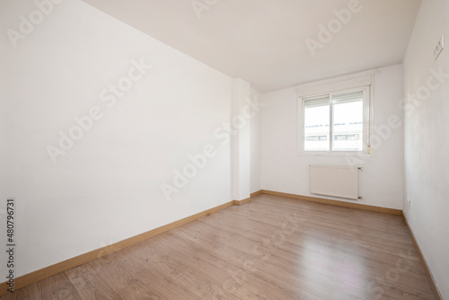 Empty room freshly painted with sliding aluminum windows and wooden floors