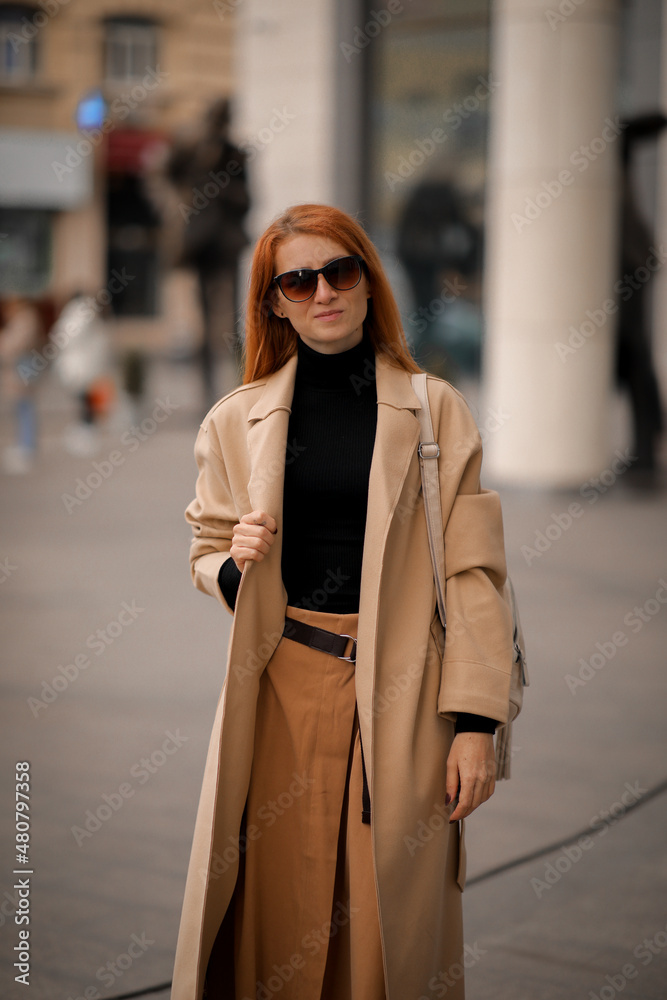 Fototapeta premium woman walking down the street. walk through the autumn city