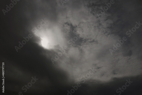 Some sunlight behind the vivid clouds of a dramatic winter sky over the ocean in California