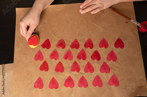 heart shaped potato stamp on craft paper. The process of decorating a gift for Valentine's Day. Getting ready for the celebration on February 14th.