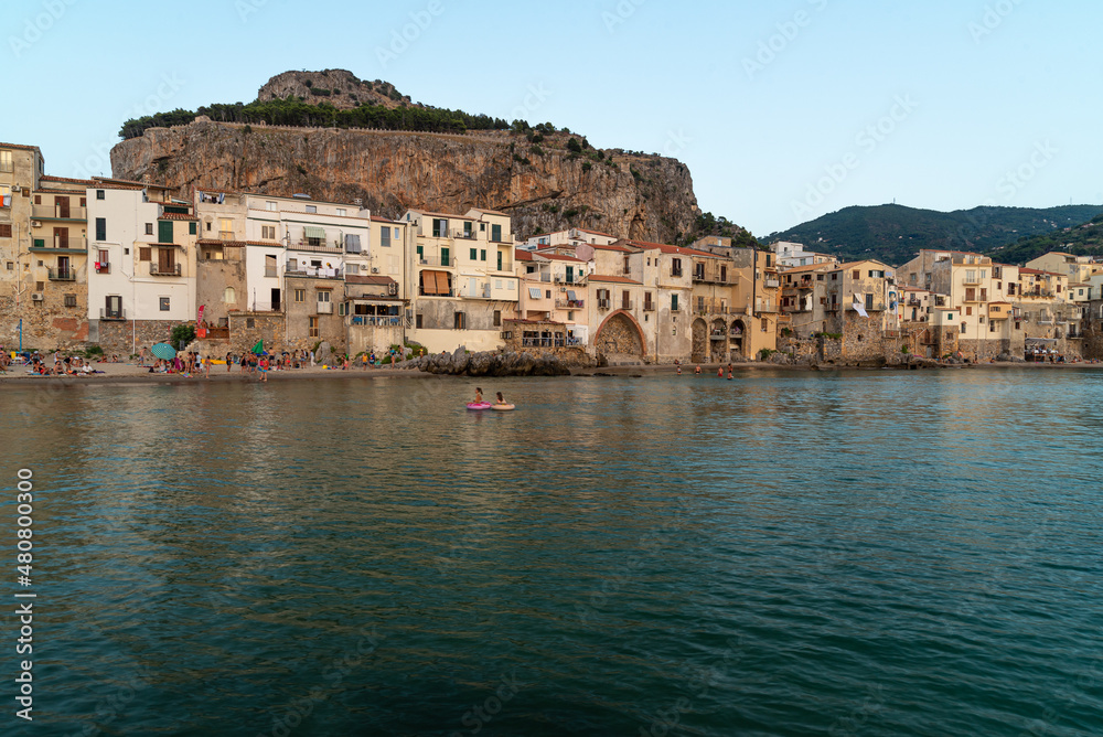 Scenic view of Cefalu town in Siciliy at sunset with sea bathers tourists