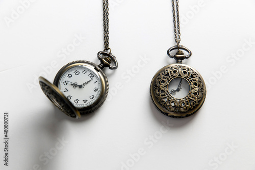 Pocket watch with chain closed and open on white background